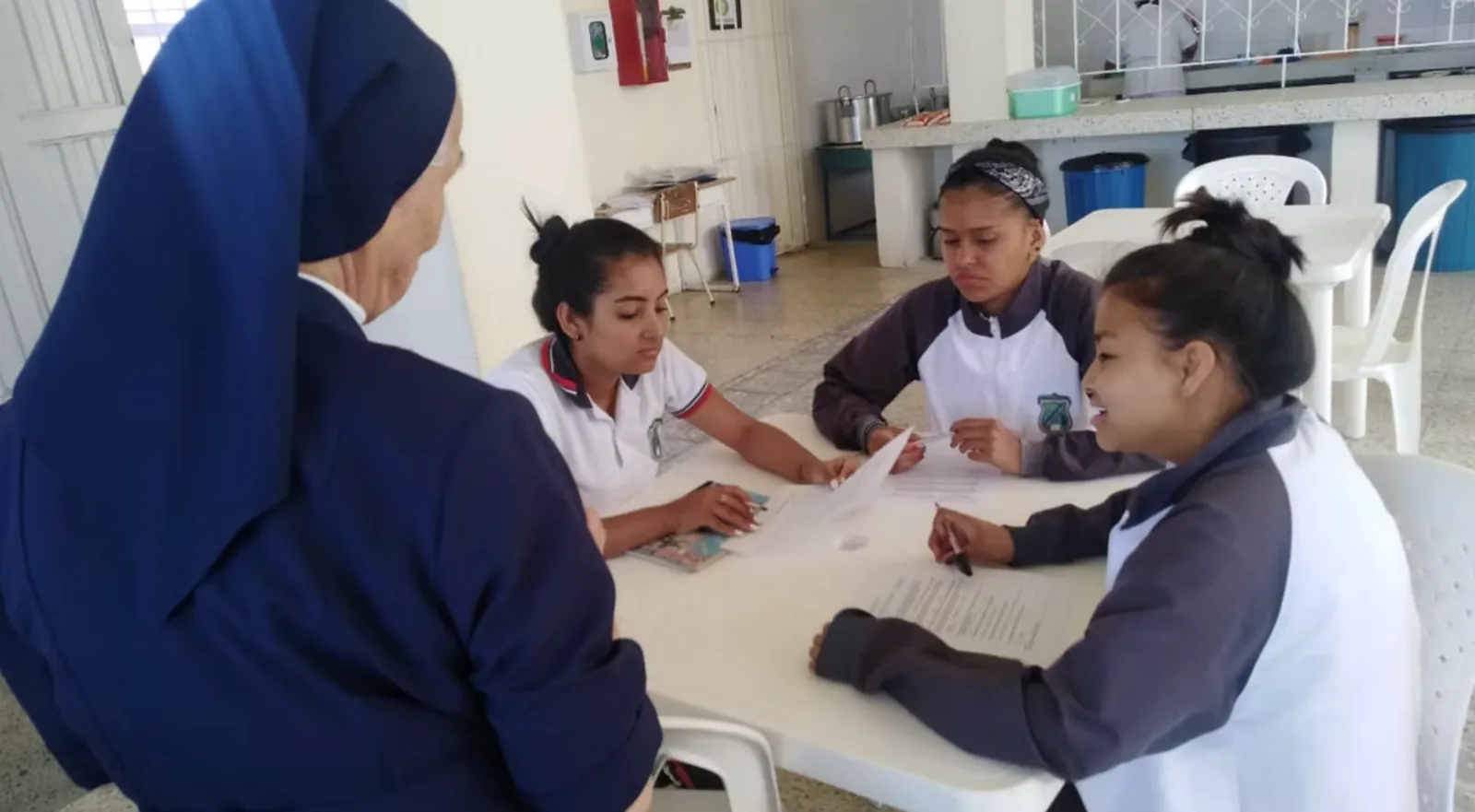 Una hermana vicentina acompaña a jóvenes estudiantes en sus tareas